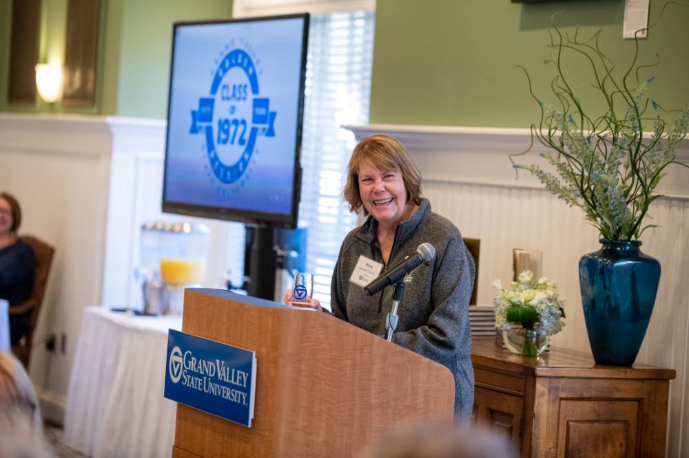 An alumni speaking at the podium.